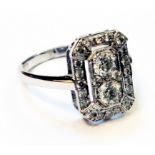 An 18ct. white gold 1920's style diamond encrusted panel ring with two central open set brilliant