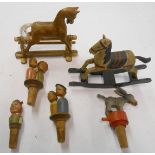 A box containing two miniature rocking horses and novelty carved wood bottle stoppers