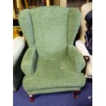 AN UPHOLSTERED WING BACK ARMCHAIR