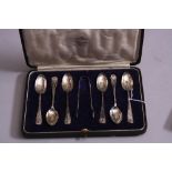 A CASED SET OF SIX SILVER TEASPOONS, and a matched set of tongs having shell terminals, spoons