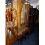 A WALNUT GLAZED SINGLE DOOR CHINA CABINET, a nest of two tables and a telephone table (3)