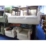 A CREAM UPHOLSTERED THREE PIECE SUITE, comprising of a three seater settee and a pair of armchairs