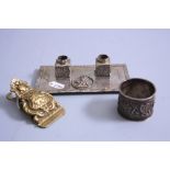 AN ORIENTAL WHITE METAL NAPKIN RING, having relief moulded figures before pagoda and script mark