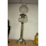 A BRASS OIL LAMP, Cornthian column, clear cut glass well and a glass shade