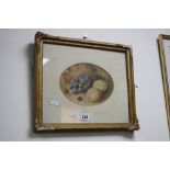 A GILT FRAMED OVAL STILL LIFE STUDY, grapes, apples and nuts on mossy ground, watercolour,