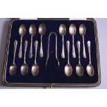 A GEORGE V CASED SET OF TWELVE SILVER COFFEE SPOONS, and sugar tongs, cast feathered style