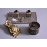 AN ORIENTAL WHITE METAL NAPKIN RING, having relief moulded figures before pagoda and script mark