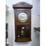 AN OAK CASED WALL CLOCK (key and pendulum)