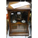 AN OAK SMOKER'S CABINET, with front opening glazed door, with ceramic tobacco jar (re-glued lid) and