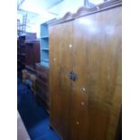 A WALNUT FOUR PIECE BEDROOM SUITE, comprising a two door wardrobe, chest of five long drawers, a