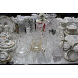 A COLLECTION OF CUT GLASS VASES, DRINKING GLASSES, JUG WITH PLATED STRAINER LID, CANDLESTICKS, etc