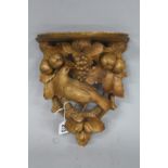 A LATE 19TH CENTURY BLACK FOREST WALL BRACKET, carved with a bird on a branch with fruit and nuts,