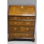 A CROSSBANDED WALNUT BUREAU, fall front to fitted interior with central cupboard flanked by pigeon