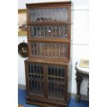 A GLOBE WERNICKE WALNUT LEAD GLAZED FOUR SECTION BOOKCASE, with cornice and lower drawer, the