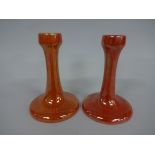 TWO RUSKIN POTTERY CANDLESTICKS, having swept circular foot supporting tapering column with