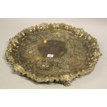 A SILVER PLATED TRAY, having moulded shell and scroll border to circular rim, engraved floral and