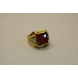 A MODERN RED GLASS GENTS SIGNET RING, ring size Z, stamped '750', gross weight approximately 10.4