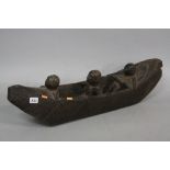 TRIBAL ART, a hardwood carved wooden canoe with three figures, the boat hull and stern with stylised
