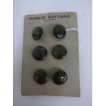 A SET OF SIX RUSKIN POTTERY BUTTONS, having moss green lustre attached to original card