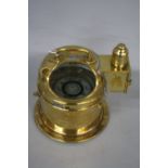 A BRASS CASED SHIP'S COMPASS, the domed top with carrying handle and oil lamp mount to side, the