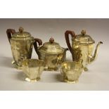 A SILVER FIVE PIECE PRESENTATION TEA SERVICE, of octagonal footed form, comprising twin handled
