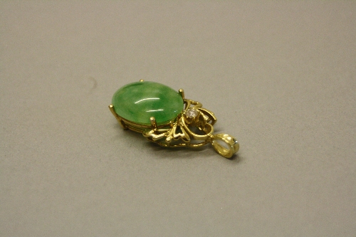 A MODERN JADE AND DIAMOND PENDANT, oval cabochon jade measuring approximately 20mm x 14.8mm, one
