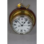 A SMITH'S SHIP CLOCK, enamel dial, Roman numerals, 7' dial, mounted on a circular wooden plaque,