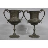 A PAIR OF VICTORIAN PEWTER TWIN HANDLED VASES, cast masks to the handles, foliate engraved and