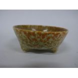 A RUSKIN POTTERY TRI FOOTED BOWL, having yellow and green mottled crystalline glaze, impressed