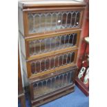 A GLOBE WERNICKE WALNUT LEAD GLAZED FOUR SECTION BOOKCASE, with cornice and lower drawer,