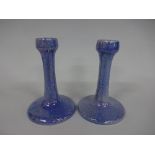 TWO RUSKIN POTTERY CANDLESTICKS, having swept circular foot supporting tapering column with