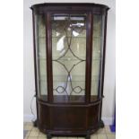 AN EDWARDIAN MAHOGANY BOW FRONTED FLOORSTANDING DISPLAY CABINET, the blind fret carved cornice above
