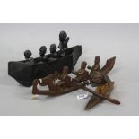 TRIBAL ART, three carved wood models of figures in canoes, maximum length approximately 42.5cm,