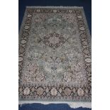 A LATE 20TH CENTURY SILK RUG, green and cream ground with foliate and animal motifs, bears label for