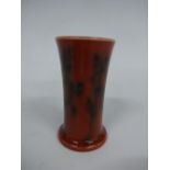 A RUSKIN POTTERY MINIATURE VASE, of flared cylindrical form on circular foot in orange glaze with