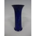 A RUSKIN POTTERY TRUMPET VASE, having flared neck, dripping blue glaze, speckled blue to base,