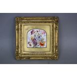 A 19TH CENTURY PORCELAIN PLAQUE, hand painted with flowers in cornucopia within arched gilt mount