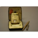 A CALIBRI 9CT GOLD AND GOLD PLATED MONOPOL CIGARETTE LIGHTER, fitted with a square dial clock,