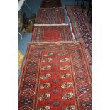 THREE 20TH CENTURY RED GROUND PERSIAN DESIGN RUGS, with multi strap borders and geometric designs,