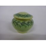 A RUSKIN POTTERY SQUAT VASE, of ovoid form, with cover having trailing leafage design in green