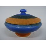 A RUSKIN POTTERY POWDER BOWL AND COVER, having flat lid and compressed knop to footed body with blue