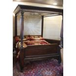 A VICTORIAN MAHOGANY FOUR POSTER BED, the pediment and head board both fitted with a cream silk