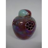 A RUSKIN POTTERY POT POURRI VASE AND COVER, having four pierced floral roundels to body in sang de