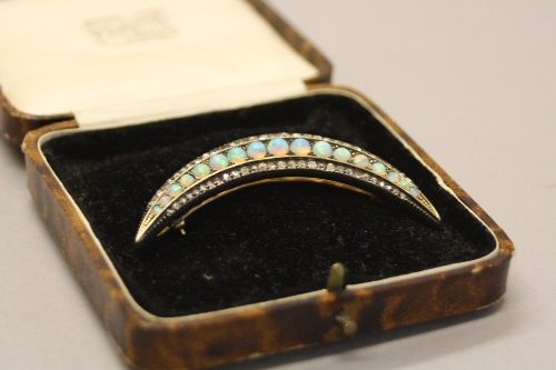 A LATE 19TH CENTURY OPAL AND DIAMOND CRESCENT BROOCH, measuring approximately 61mm in length, a