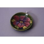 A SMALL MOORCROFT TRINKET DISH, Clematis pattern on green ground, diameter approximately 8cm