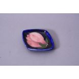 A SMALL MOORCROFT POTTERY TRINKET TRAY, Magnolia pattern on blue ground, paper label and impressed