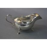 A GEORGE V SILVER SAUCEBOAT, wavy rim, 'S' scroll handle, three cabriole legs with a flattened