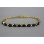 A MODERN SAPPHIRE AND DIAMOND CENTRE PIECE LINE BRACELET, nine oval mixed cut blue sapphires,