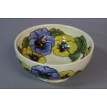 A MOORCROFT PANSY PATTERN BOWL, yellow and blue flowers, pale green ground, impressed marks,