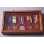 A GLAZED BOX FRAME CONTAINING A GROUP OF FIVE WWII ERA MEDALS, namely 1939-45 star, Africa Star,